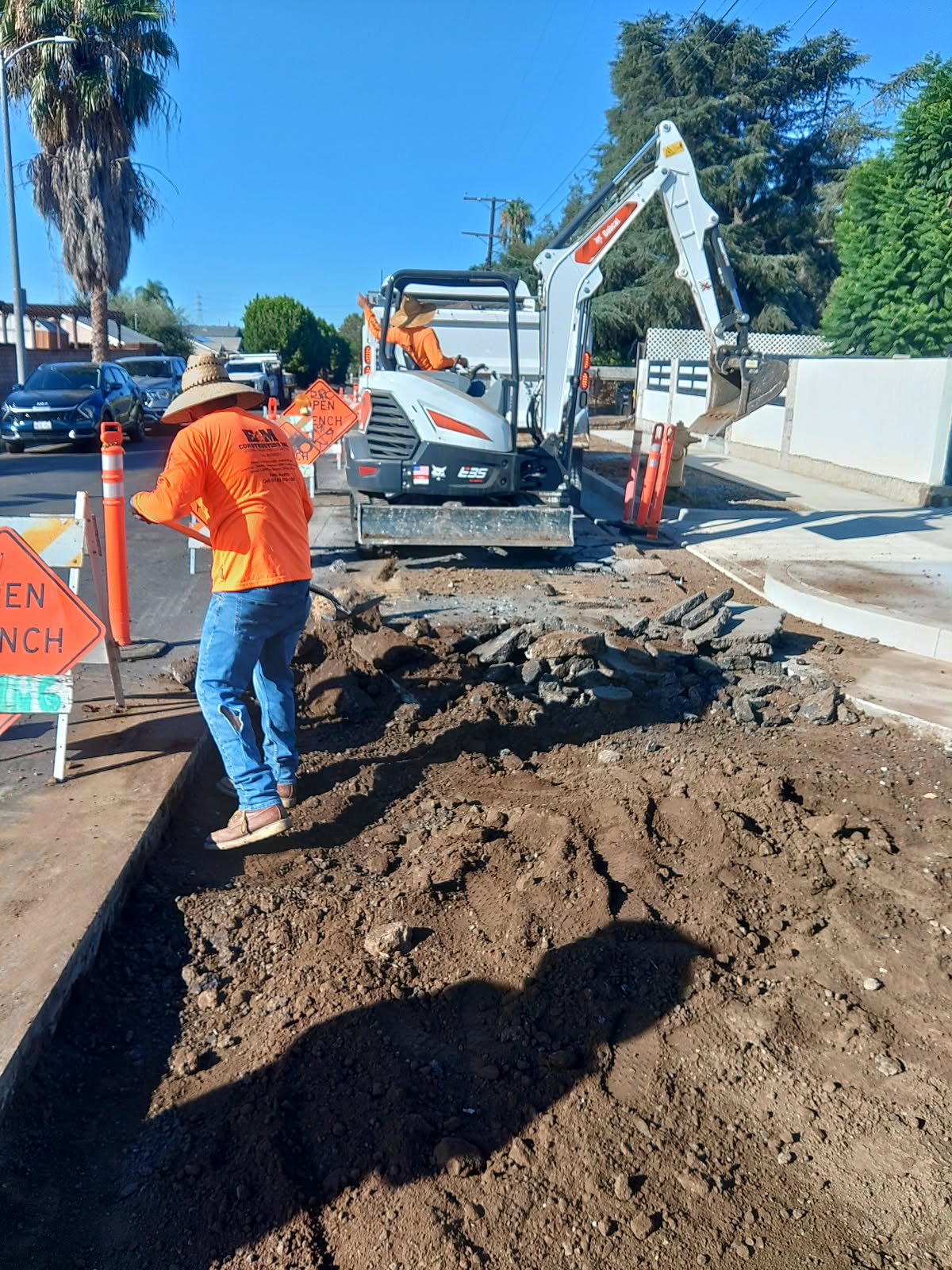 E&M crew trenching with Bobcat mini excavator